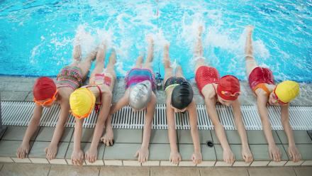 kids kicking legs in swimming pool